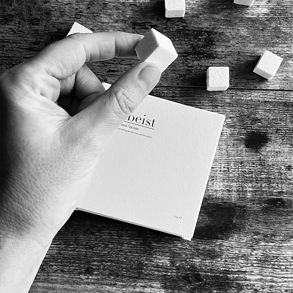 hand holding a small 3 in 1 dissolvable shower cube